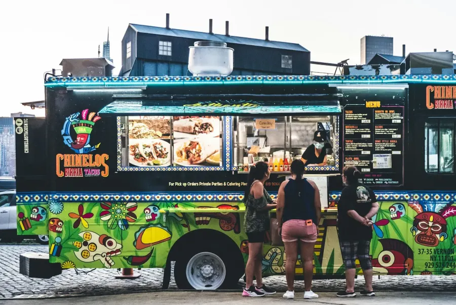 People waiting outside a food truck